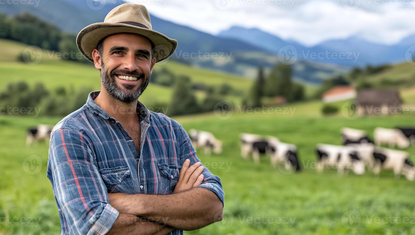 Smiling farmer stands in a lush field with cows grazing nearby. photo