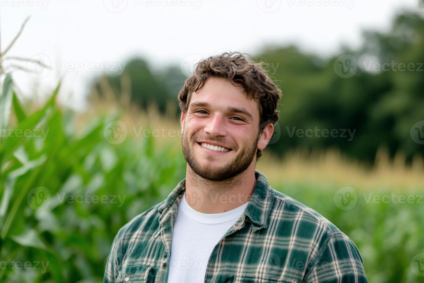 A smiling young man stands in a cornfield, showcasing rural life. photo