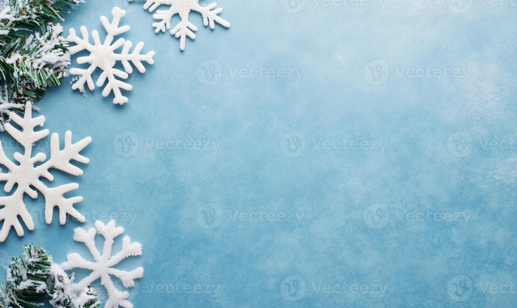 A winter-themed background with snowflakes and greenery on a blue surface. photo