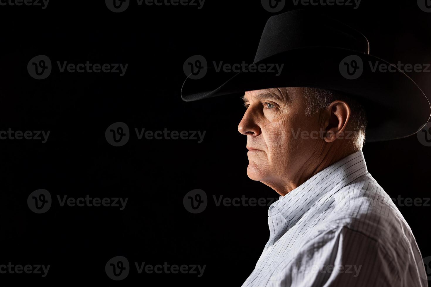 A man in a cowboy hat looking off to the side photo