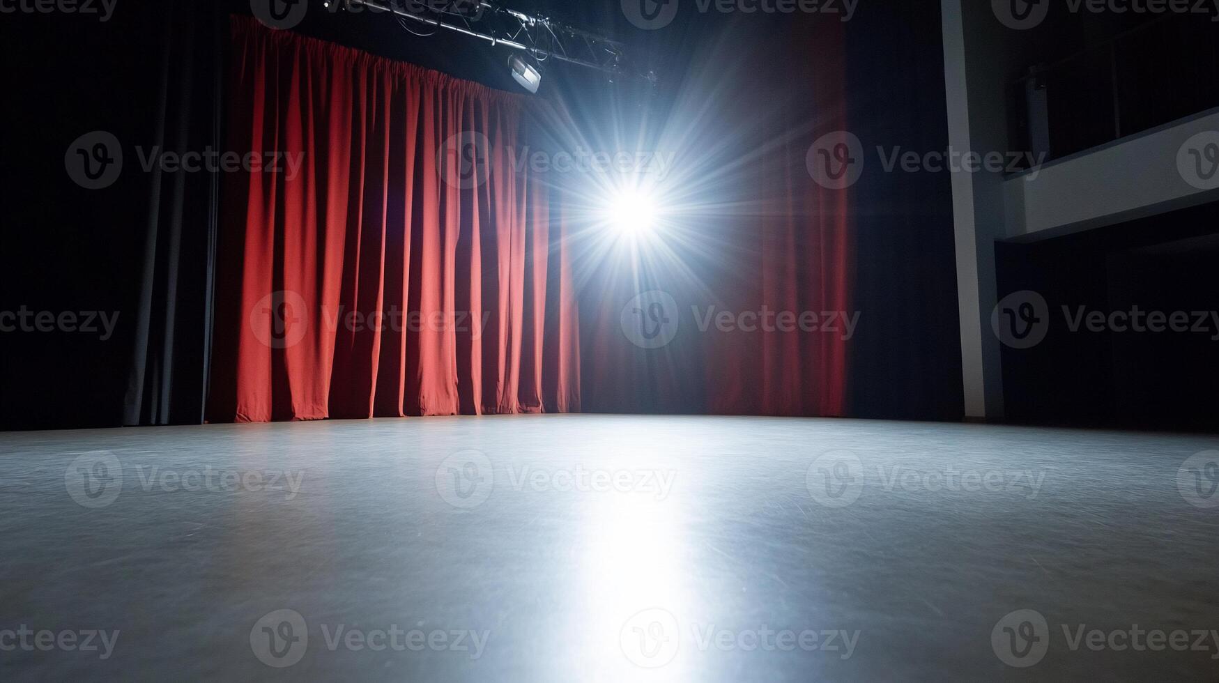 A spotlight illuminates an empty stage with red curtains in the background. photo