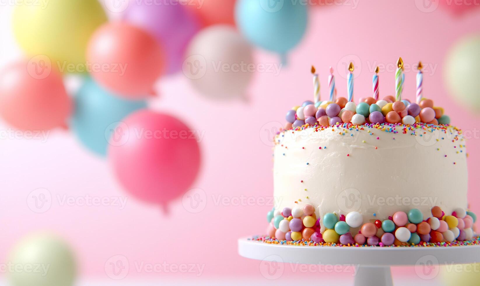 A celebratory cake adorned with colorful sprinkles and balloons. photo