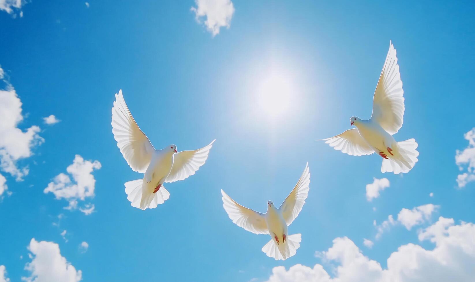 Three white doves flying against a bright blue sky with clouds. photo
