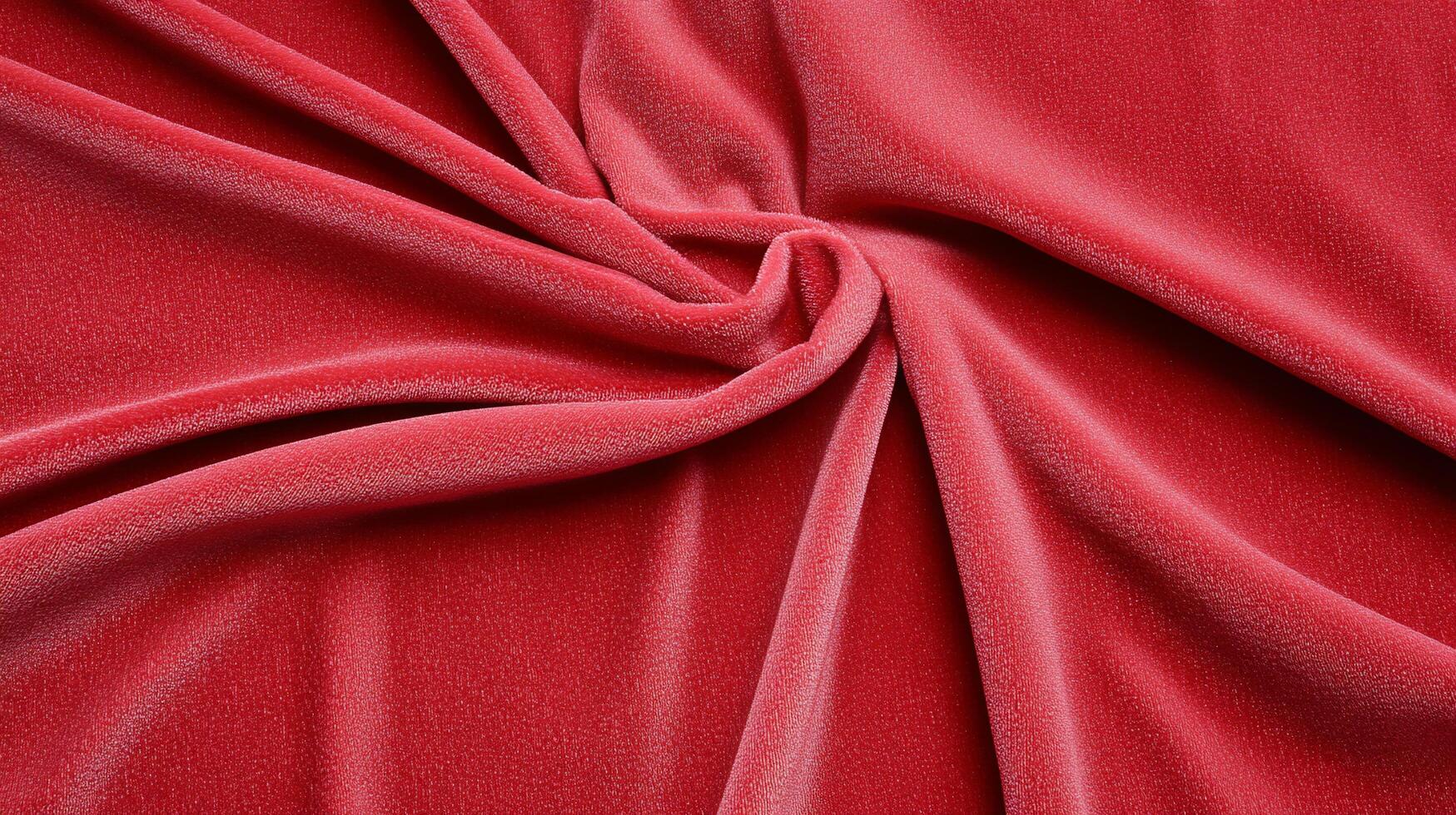 A close-up of luxurious red velvet fabric, showcasing its texture and drape. photo