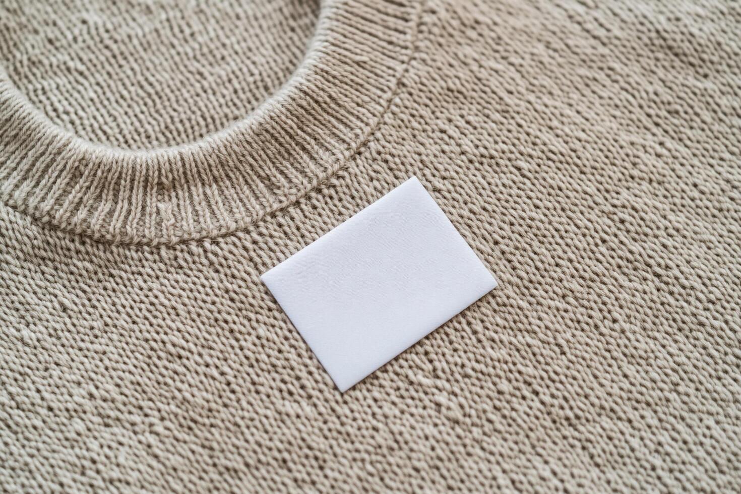 A plain white card placed on a textured beige sweater. photo