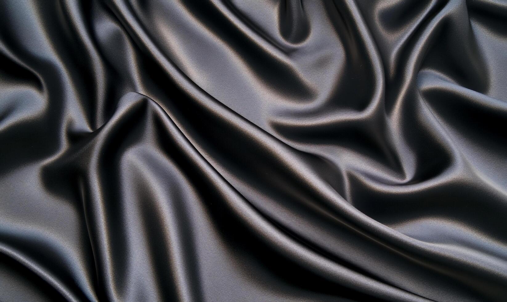 A close-up of smooth, dark fabric displaying elegant folds and textures. photo