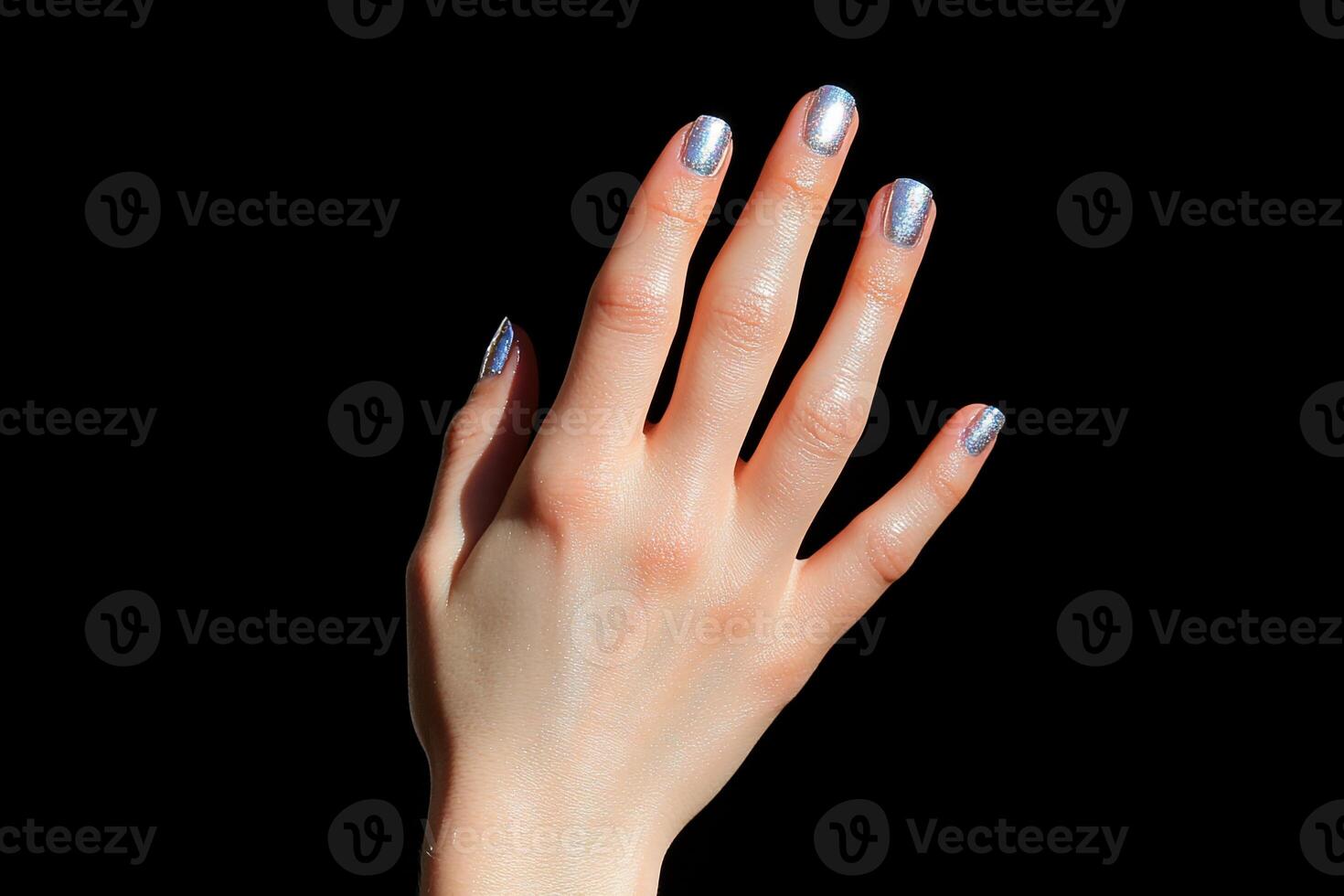 A woman's hand with silver nail polish and a white manicure photo