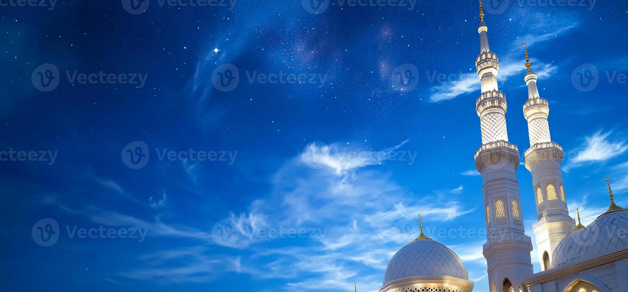 The white mosque is lit up at night photo