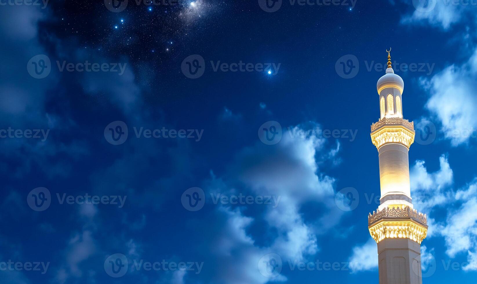 A beautifully illuminated mosque minaret against a starry night sky. photo