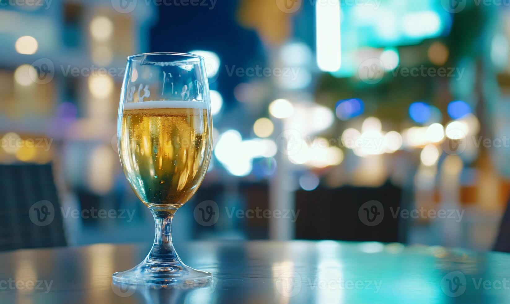 A glass of beer on a table, with a blurred nightlife background. photo