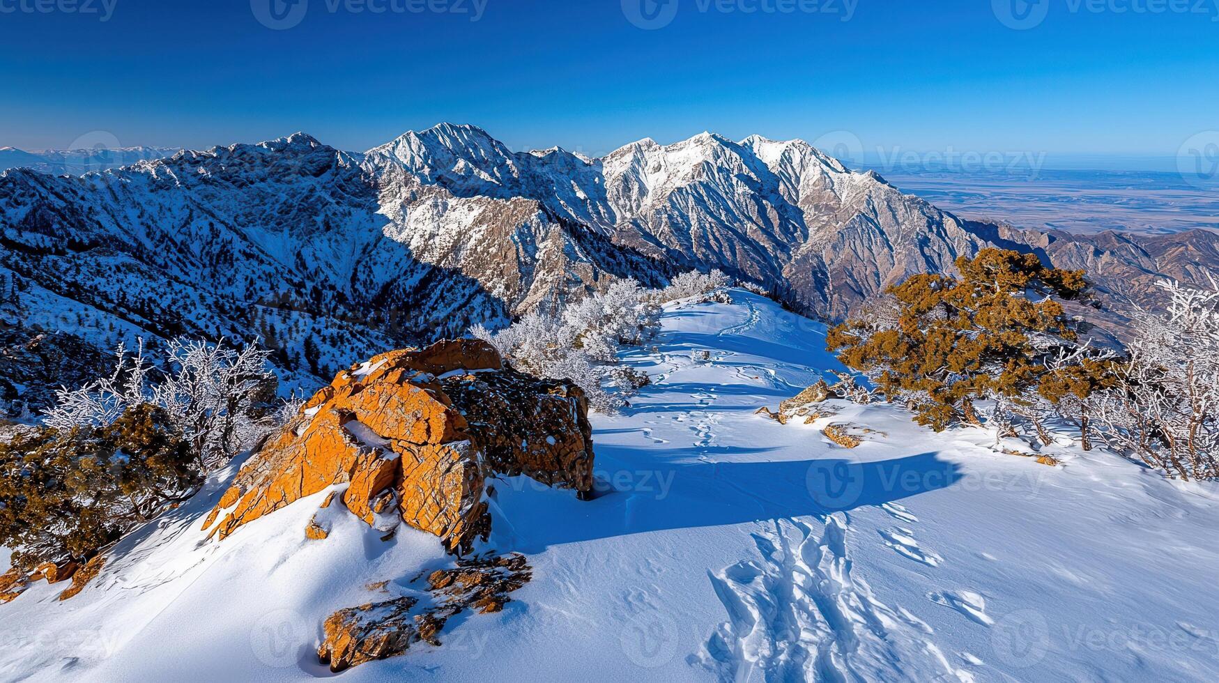 Majestic Winter Mountain Peak with Snow Covered Landscape and Footprints photo