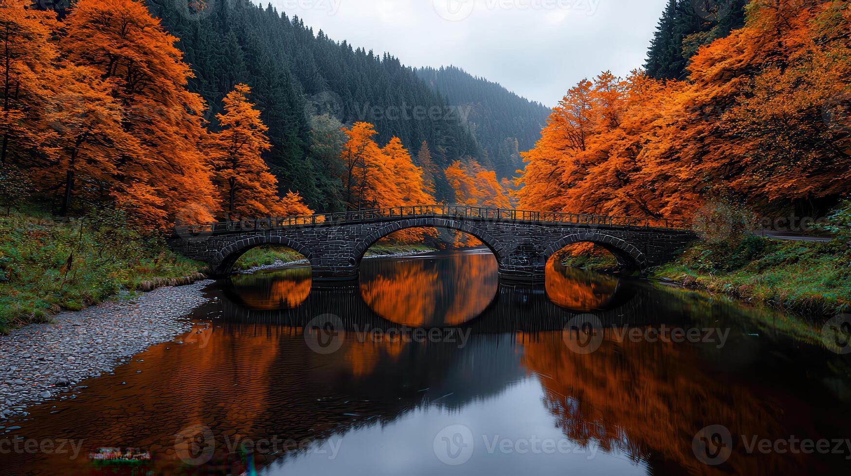 Serene Autumn Landscape Stone Arch Bridge Reflecting in Calm River Surrounded by Vibrant Fall photo
