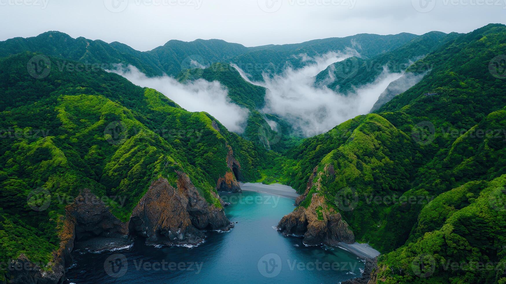 Serene Coastal Cove Surrounded by Lush Green Mountains and Misty Peaks photo