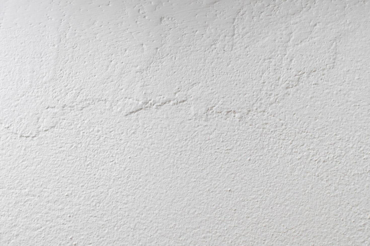 The wall is painted with white paint with a visible texture photo
