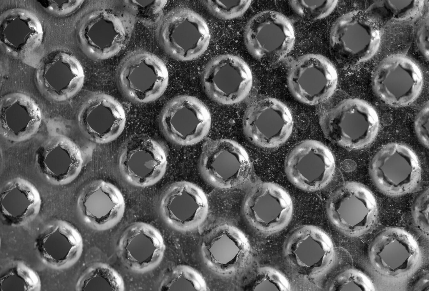 Background or texture from a gray and monophonic metal surface with symmetric and round openings. photo
