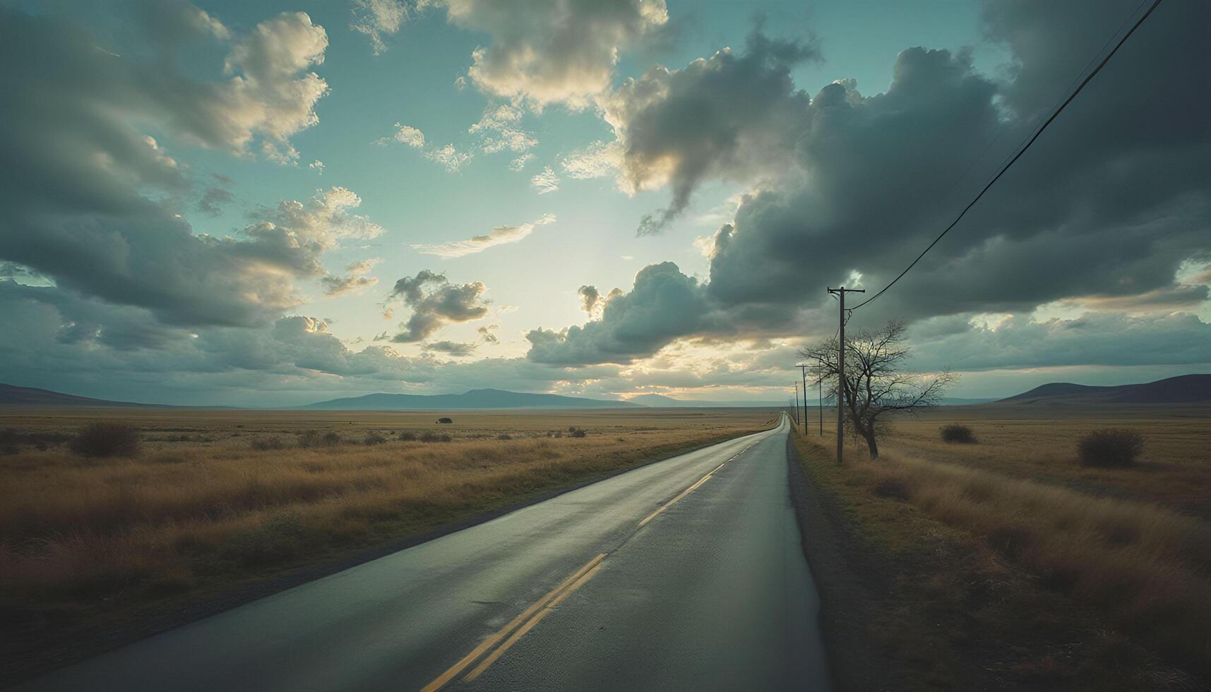 A long empty road with clouds in the sky photo