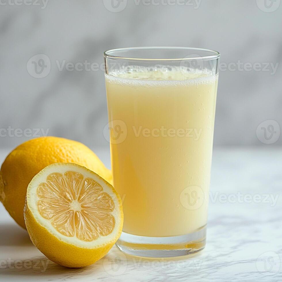 A glass of lemon juice and a half lemon photo