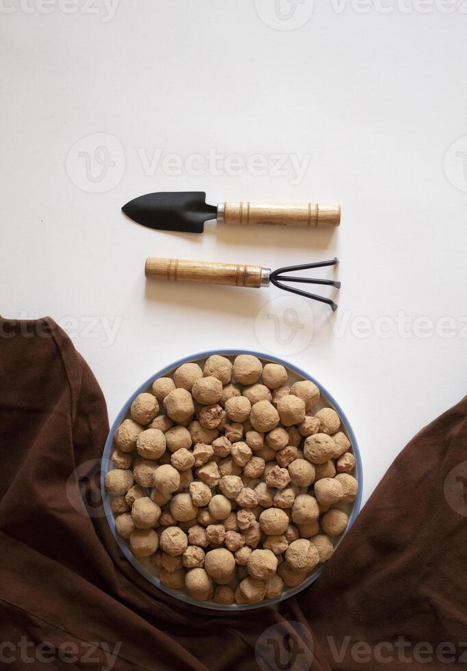 Edible caramel clay stones with a small wrack and shovel on a white background photo