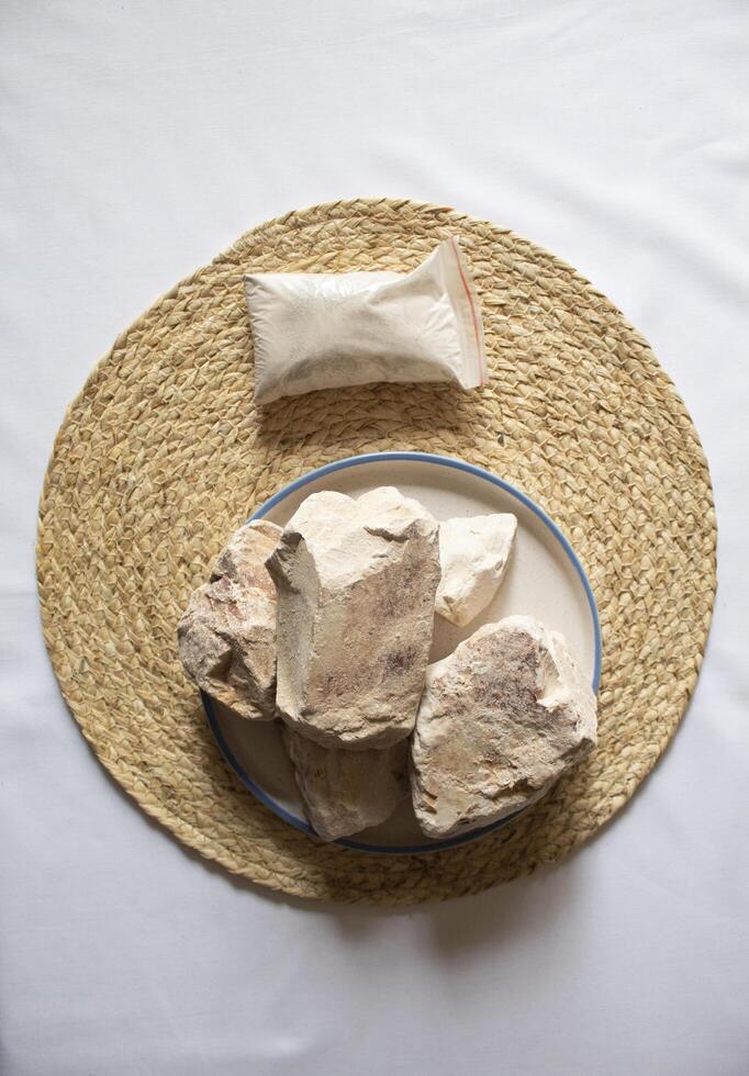 Edible White Clay Stones, with a small clay powder pack minimal flat lay photo