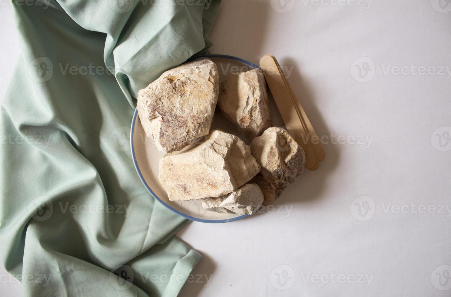 Edible White Clay Stones in a round plate, with sticks minimal flat lay photo