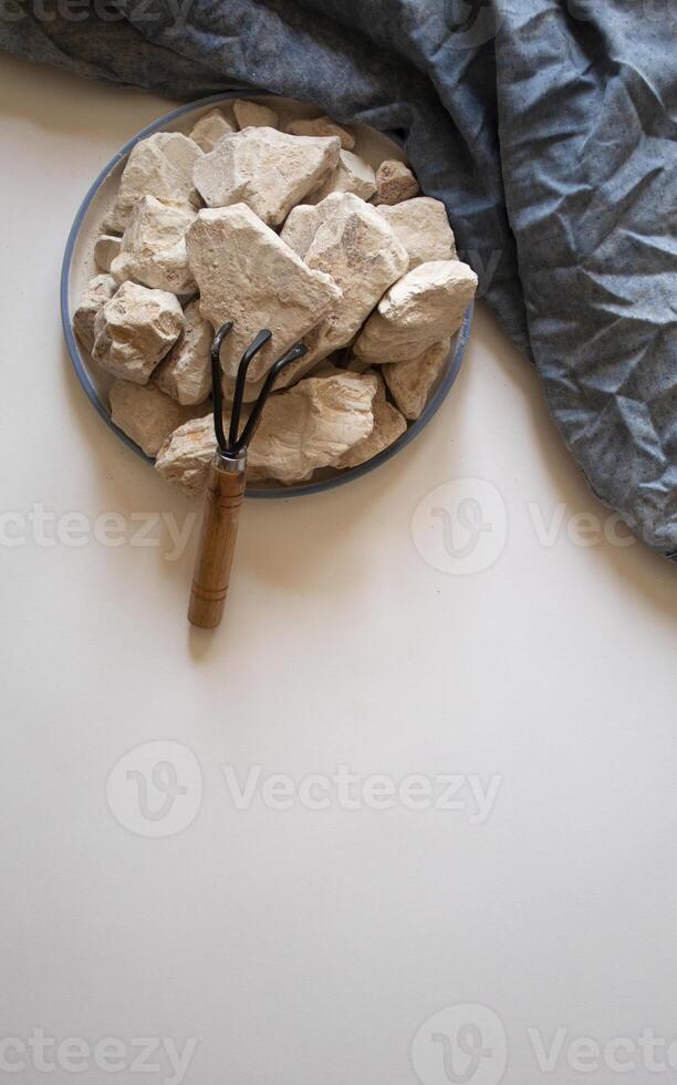 White clay stones with a small wrack on a white background flat lay photo