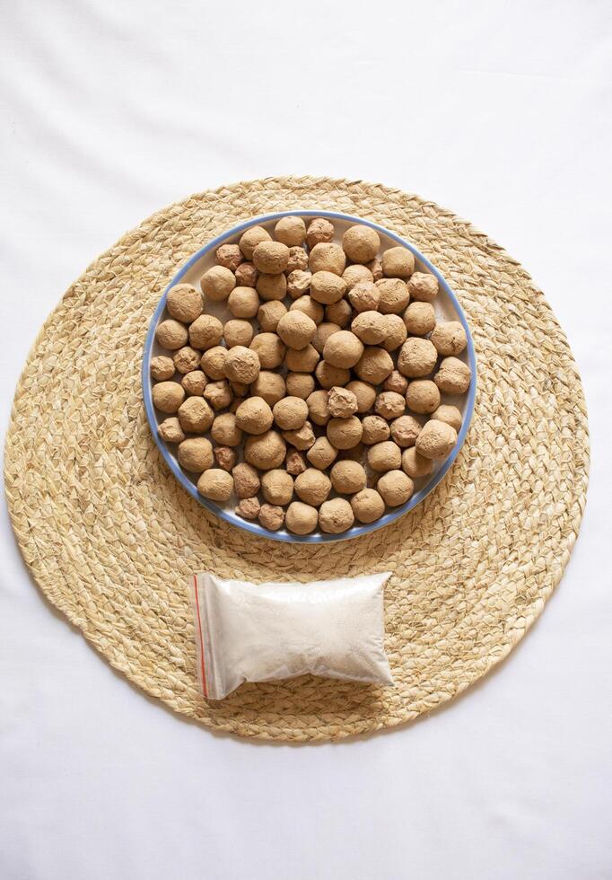 Edible Caramel Clay Stones in a round plate with a powder clay pack minimal flat lay photo