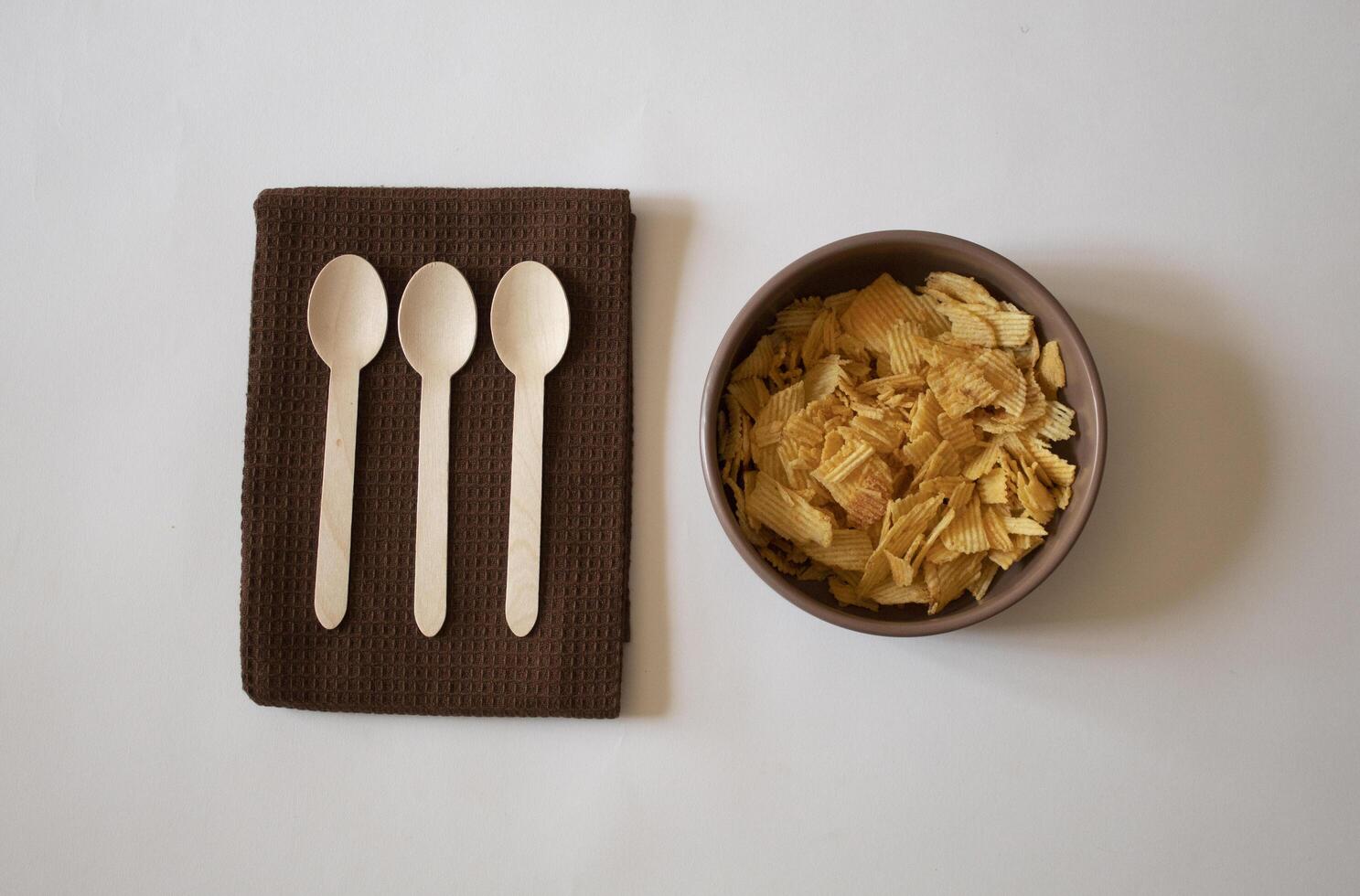 Potatoe chips and spoons on a white background flat lay photo