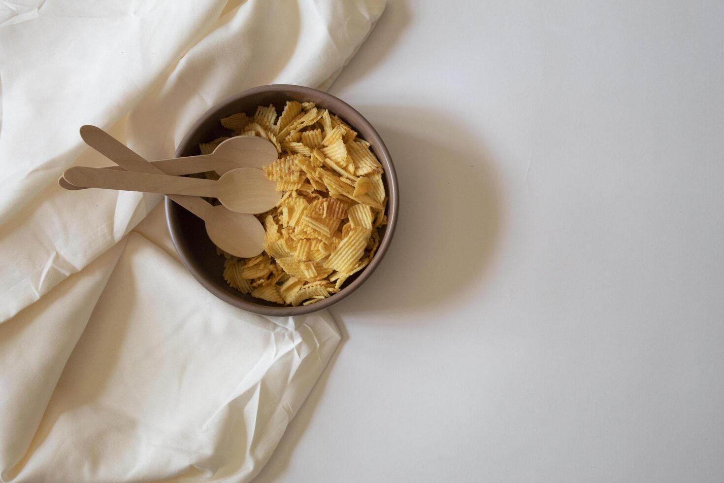 Potato chips and spoons on a white background minimal flat lay photo