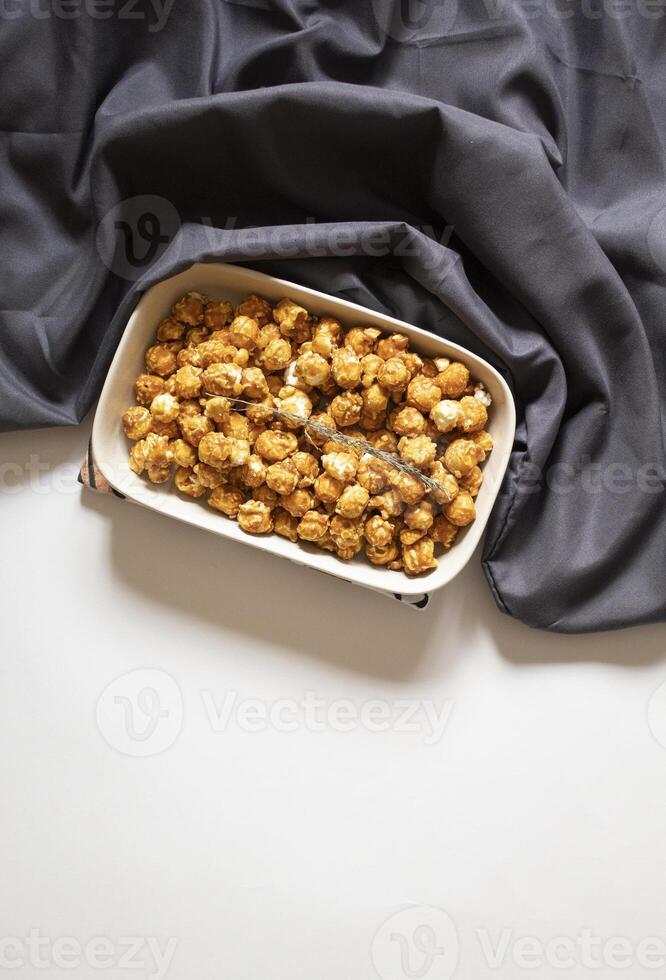 Caramel popcorn on a white background minimal flat lay photo