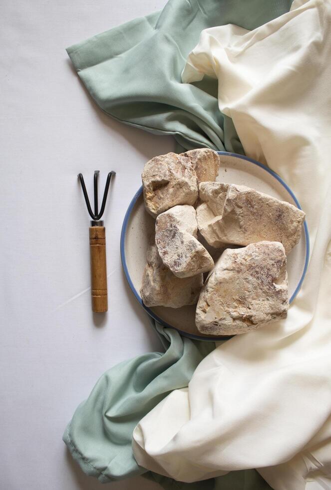 Edible White Clay Stones with a small garden wrack minimal flat lay photo