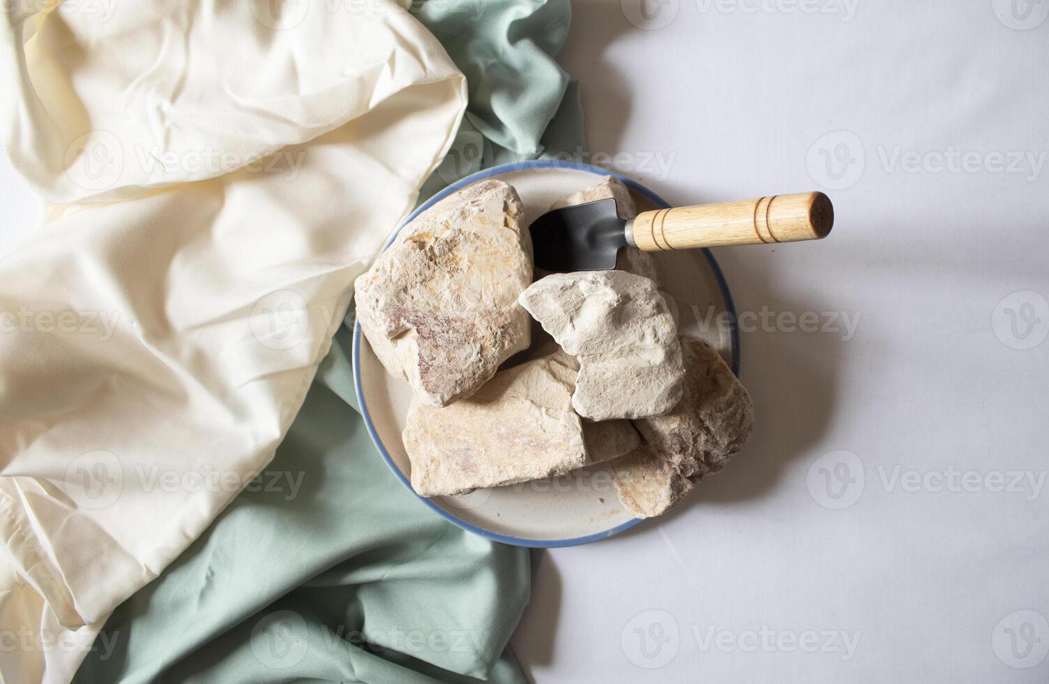 Edible White Clay Stones on round plate, with a small shovel flat lay photo