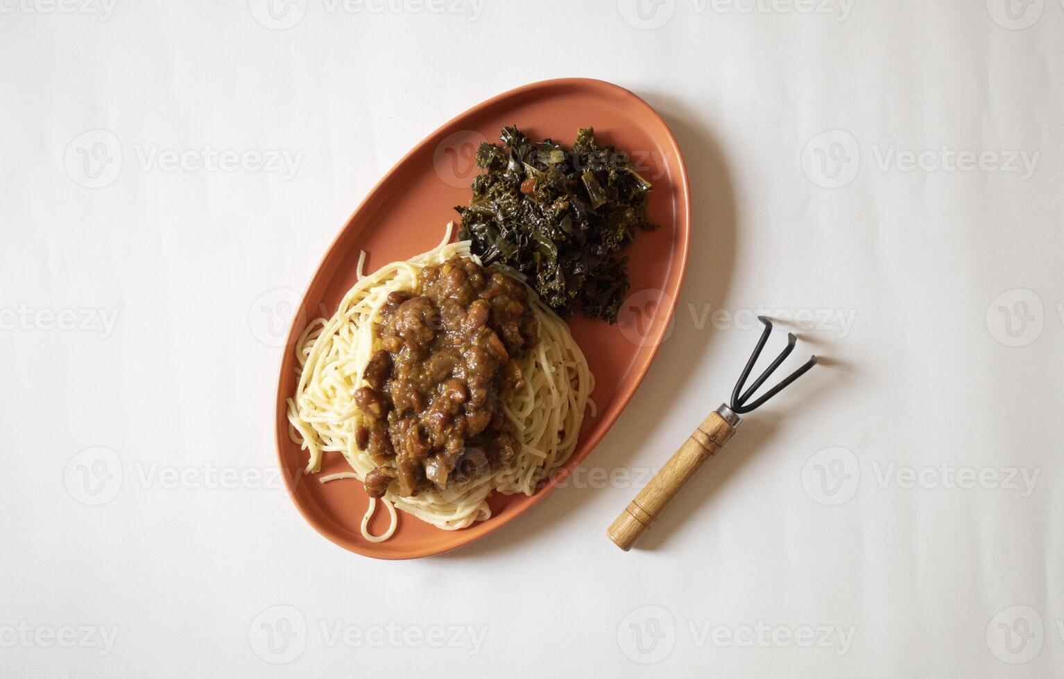 Spaghetti and green vegetables with a small garden fork minimal flat lay photo