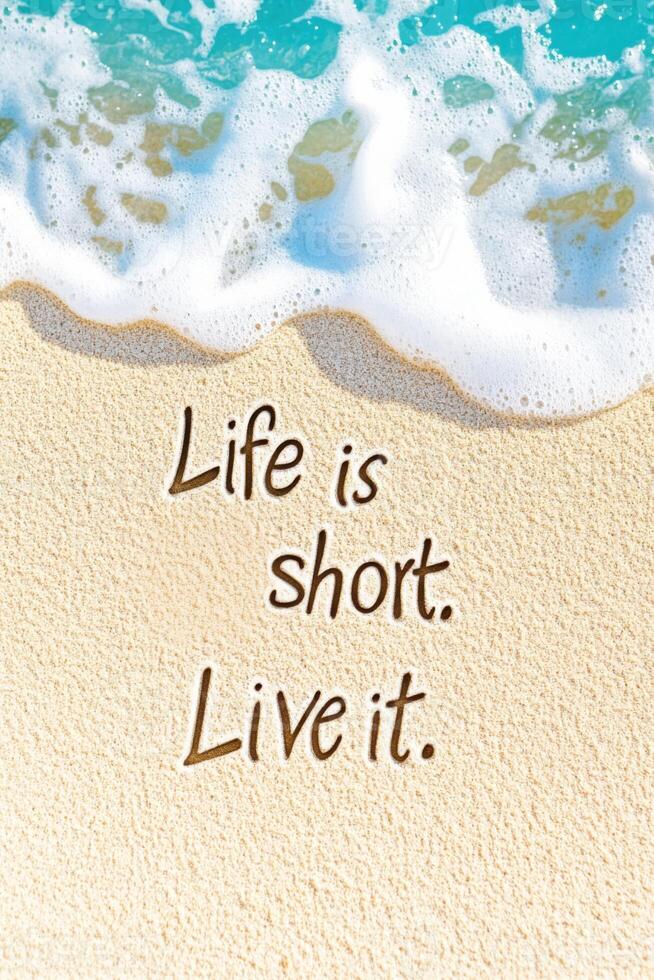 Inspirational quote written in sand on a sunny beach with gentle waves crashing in the background photo