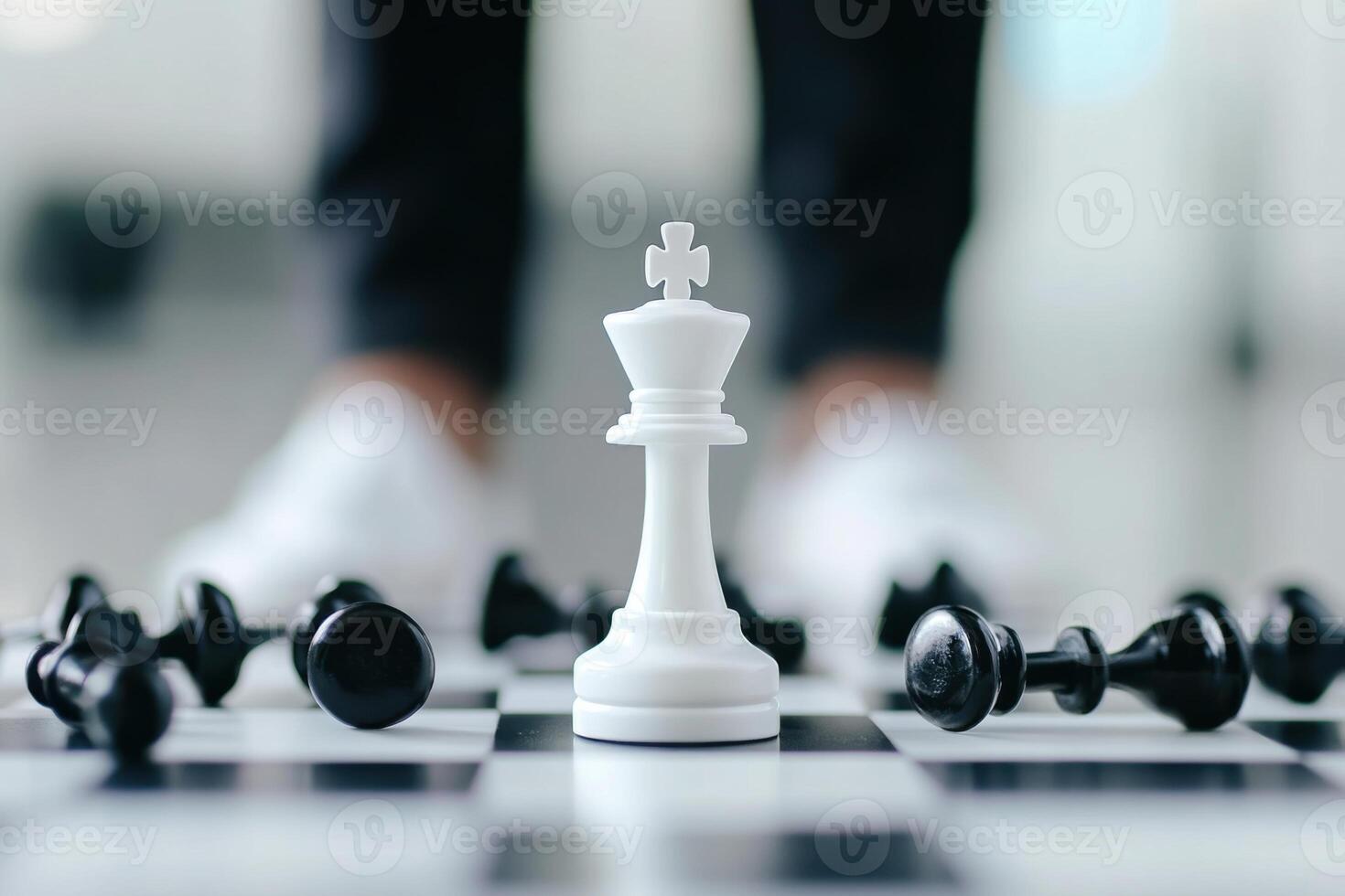 Minimalist chessboard featuring a single white king surrounded by fallen black pieces representing strategy and victory in a timeless game photo