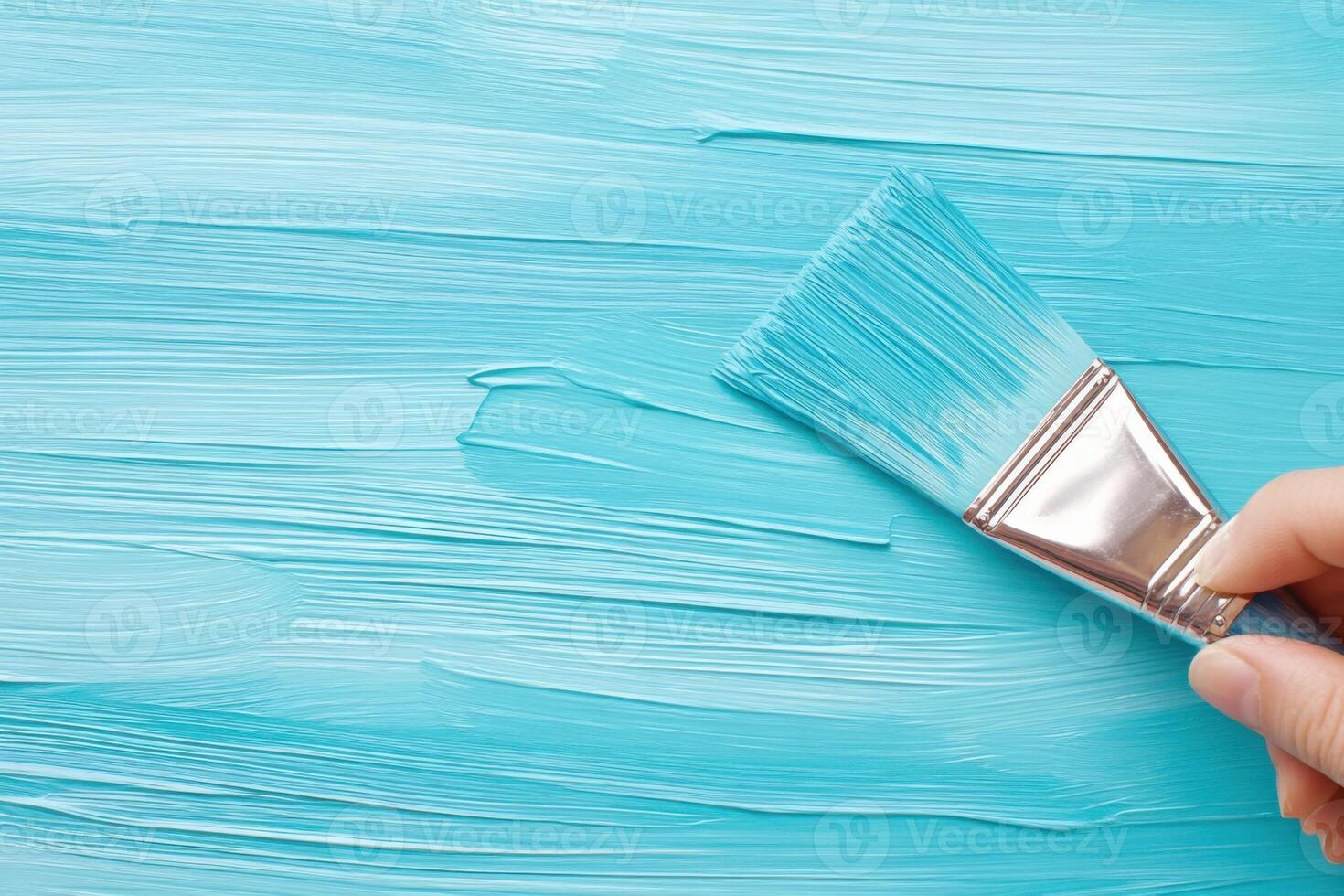 Close-up of a painter applying vibrant blue paint with a wide brush for smooth and professional finish in an artistic workspace photo