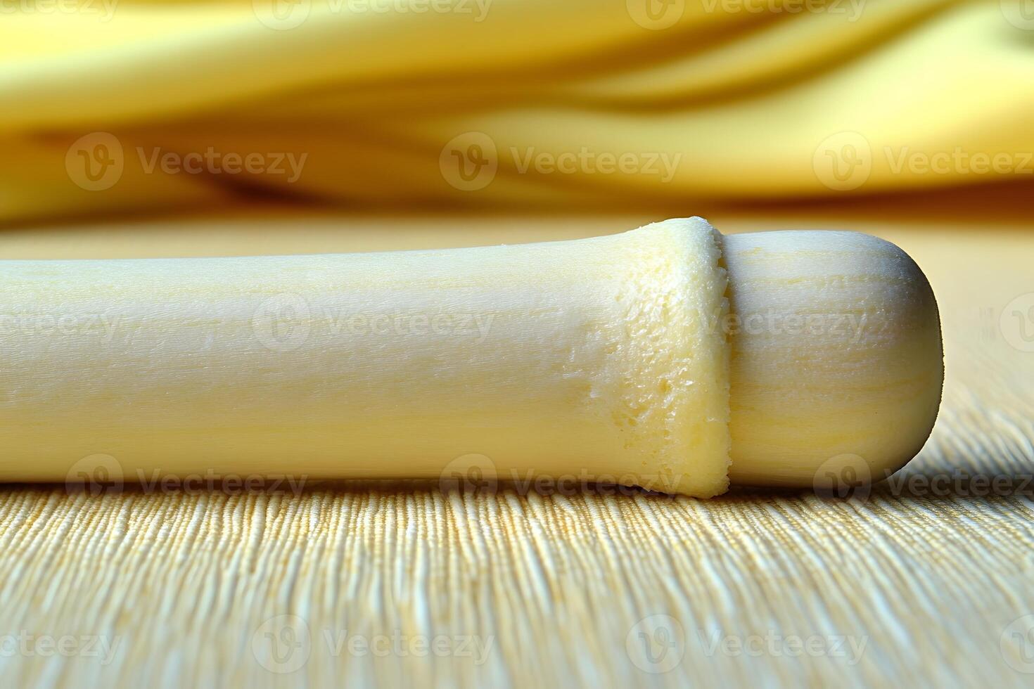 Close-Up of Wooden Rolling Pin on Yellow Fabric for Kitchen Decor photo