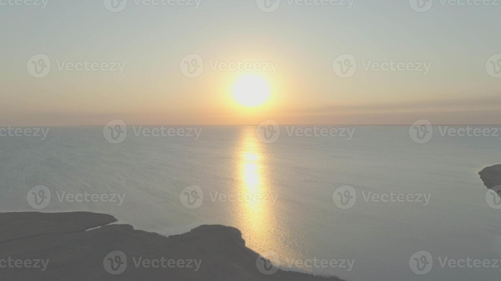 Sunrise above sea from land photo