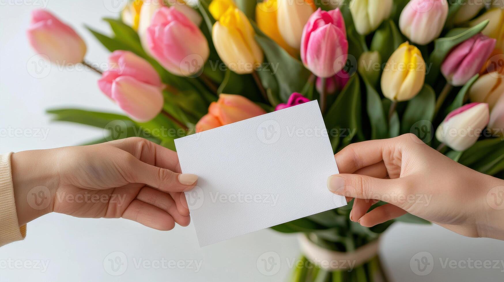 Close-up of mother and daughter exchanging a card while surrounded by vibrant tulips in a sunny room photo