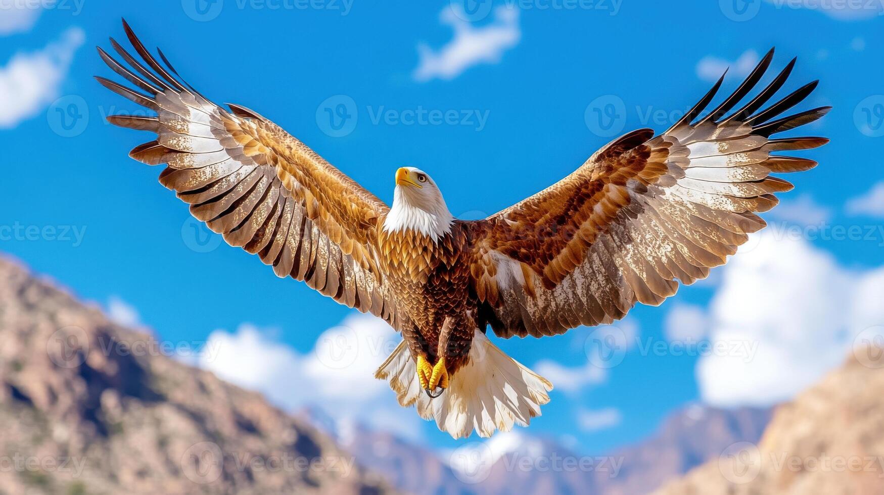 Majestic eagle soars high above a stunning mountain range with expansive wings spread wide under a clear blue sky photo