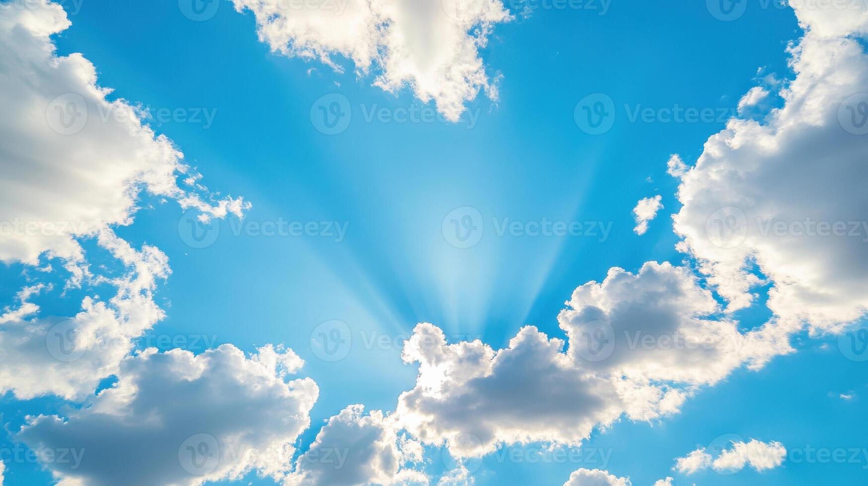 Bright blue sky with fluffy clouds and radiant sunlight breaking through during midday hours photo