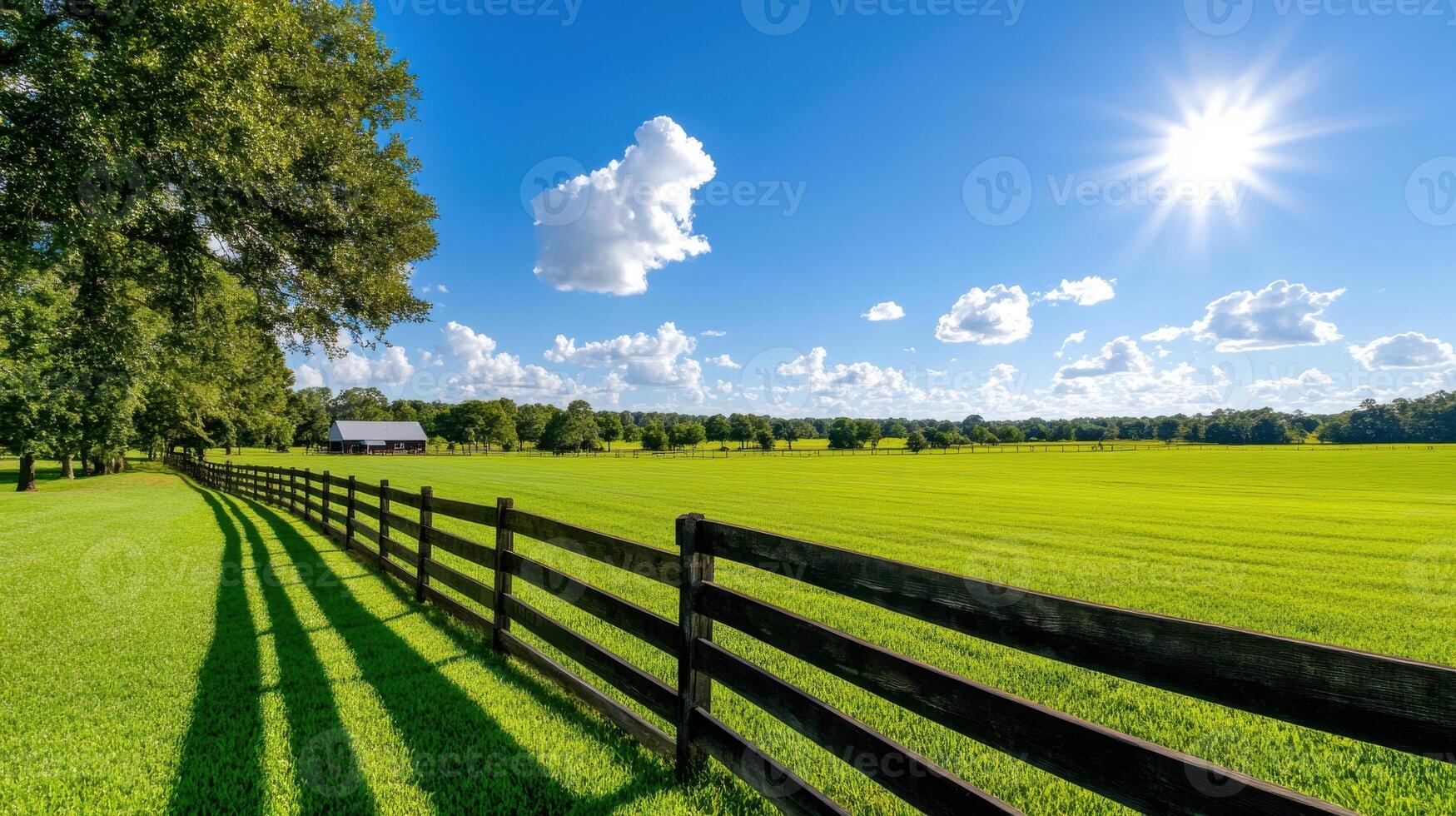 Golden sunlight filters through fields creating a serene atmosphere with a wooden fence and vibrant green grass photo