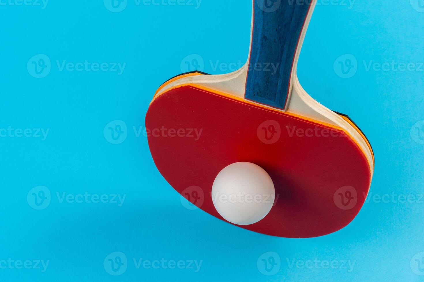 Red ping pong racket on a blue background photo