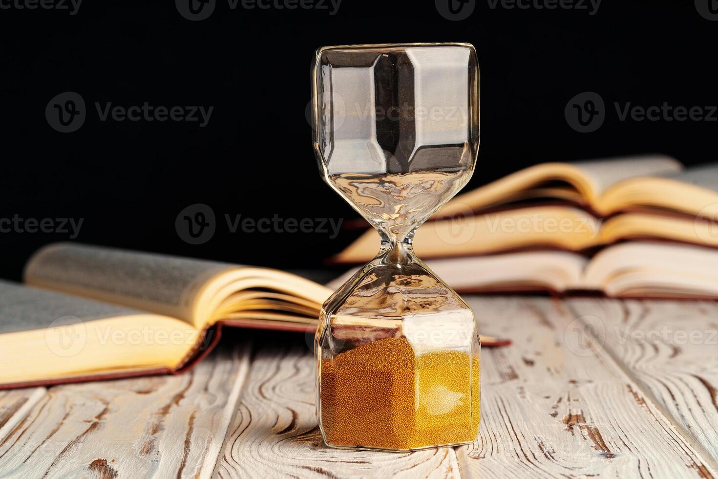 Closed up of sandglass or hourglass on background of book photo
