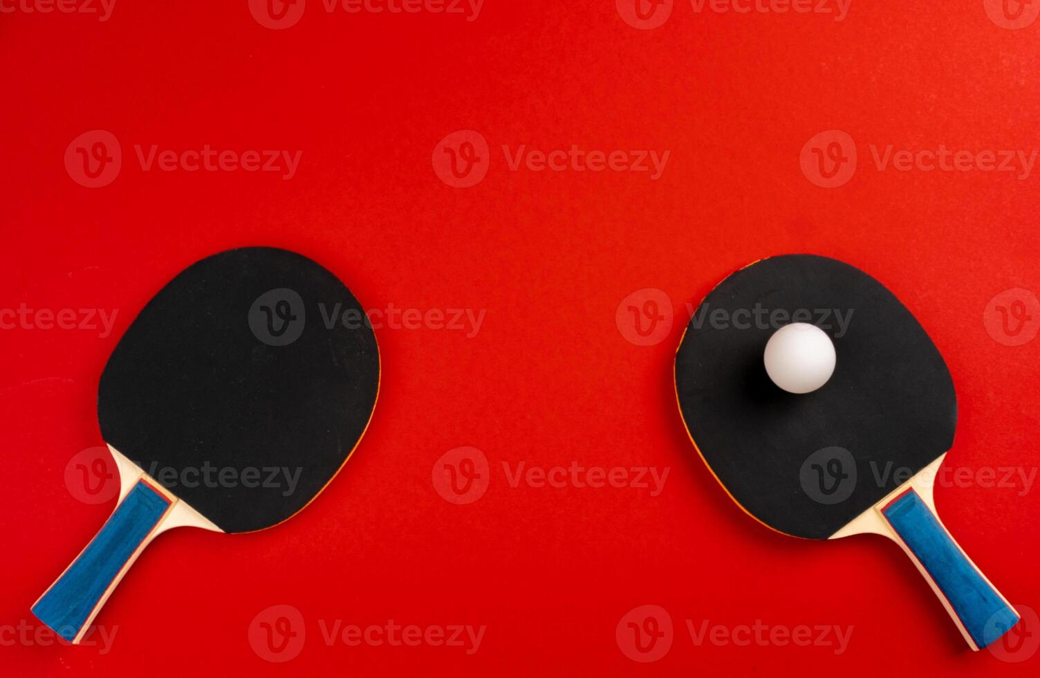 Black ping pong rackets on red background photo