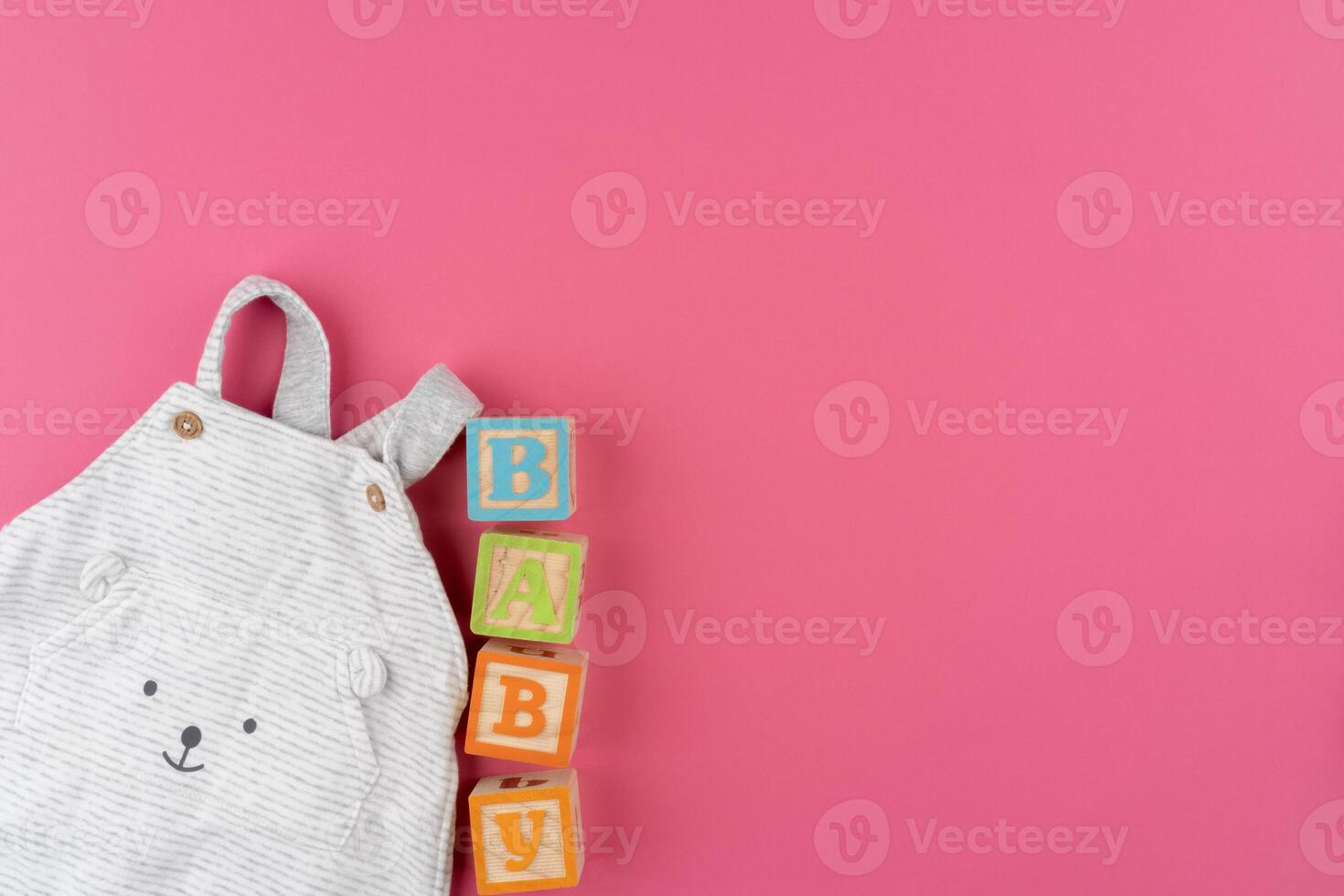 baby clothes on pink background top view photo