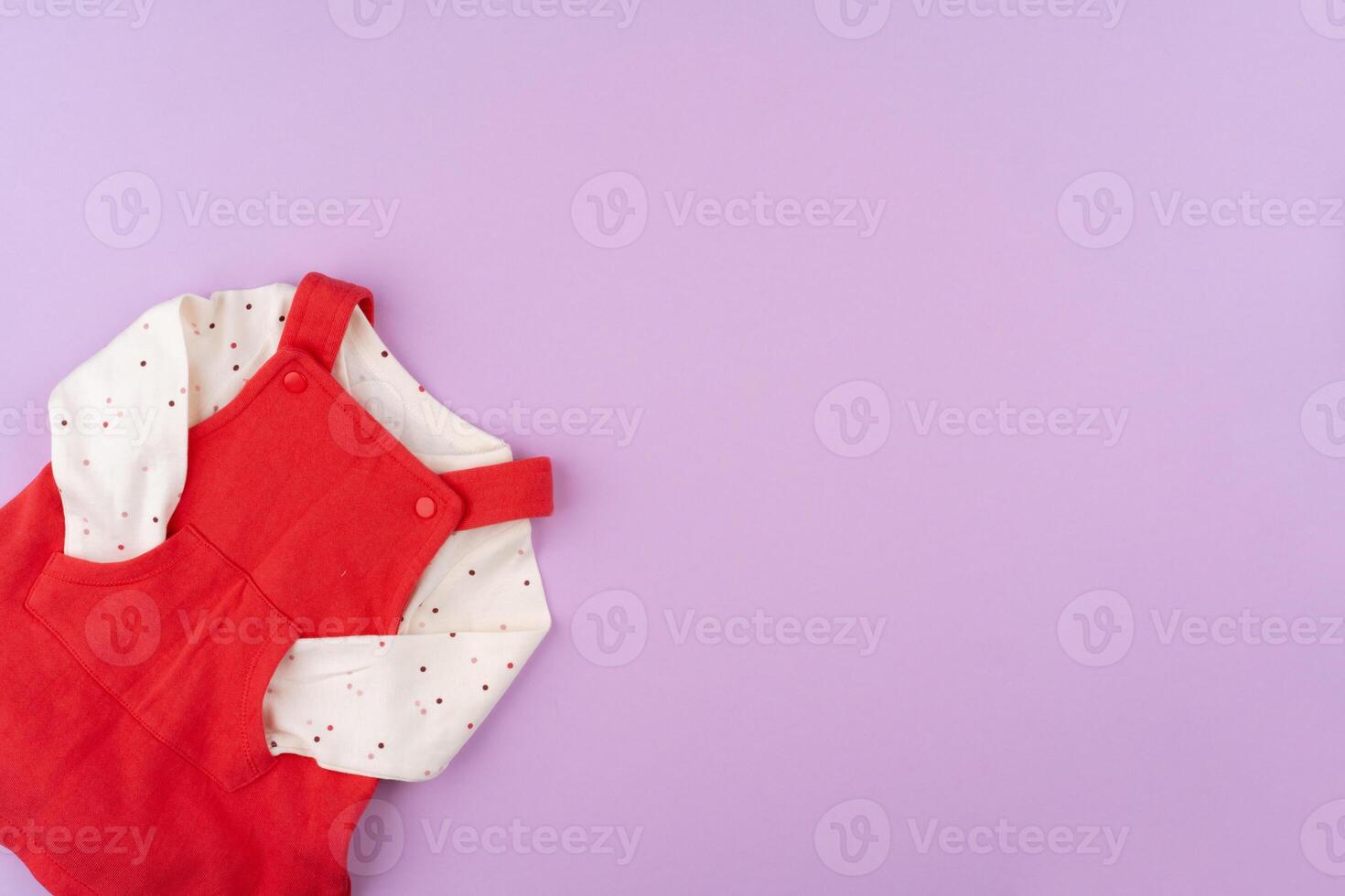 Baby girl clothes on lilac pastel background photo