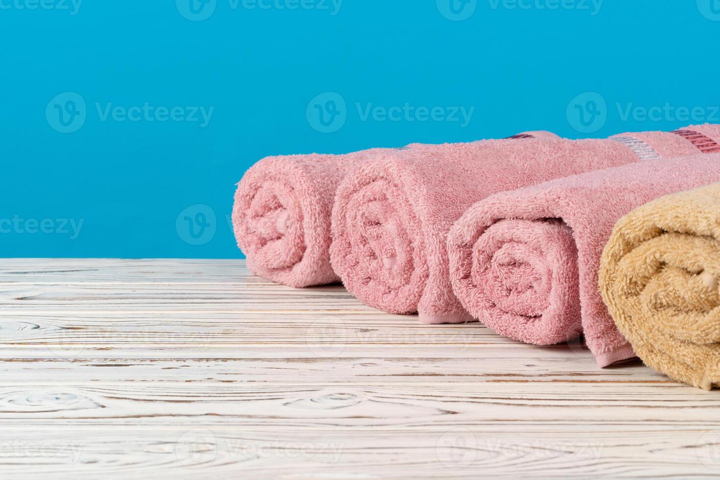 Stack of rolled towels on a wooden table photo
