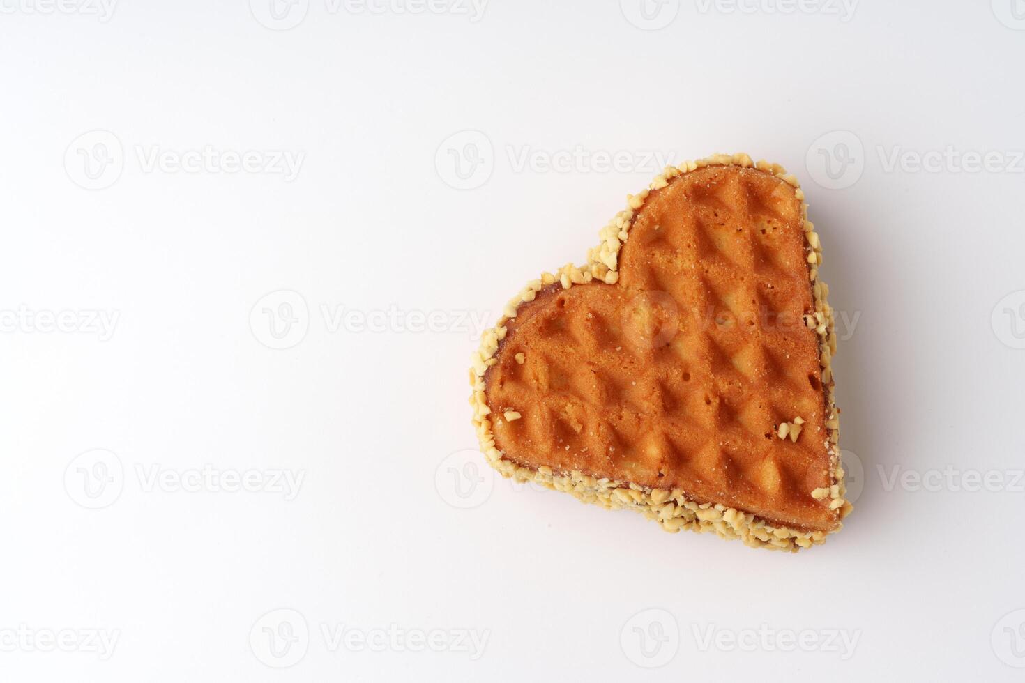 Heart-shaped waffle crafted from golden batter adorned with a crispy texture showcased against a white background photo