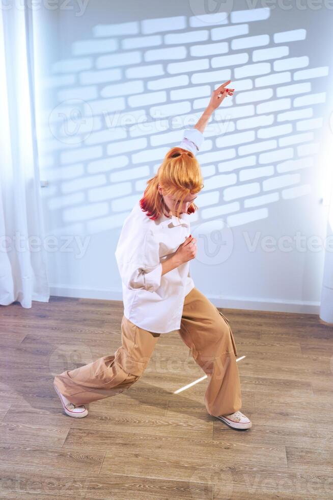 Dancer showcases expressive movement in a bright indoor space with shadow patterns on the wall photo