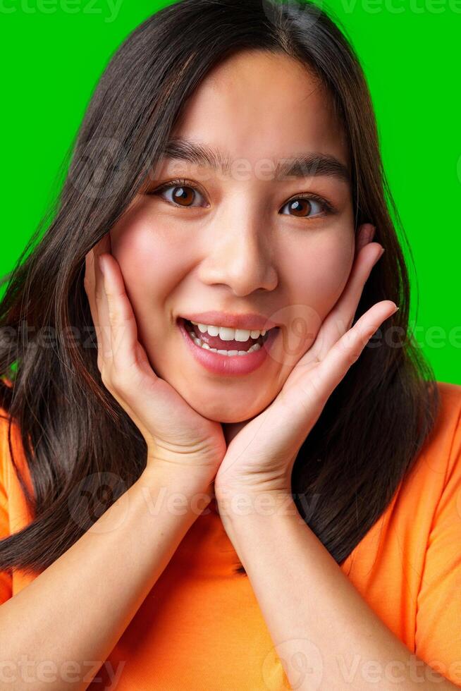 Excited young woman expressing joy against a bright green background photo